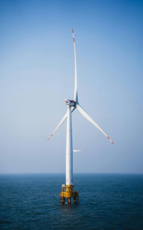 Imagen de un molino de viento en alta mar como ejemplo de sostenibilidad